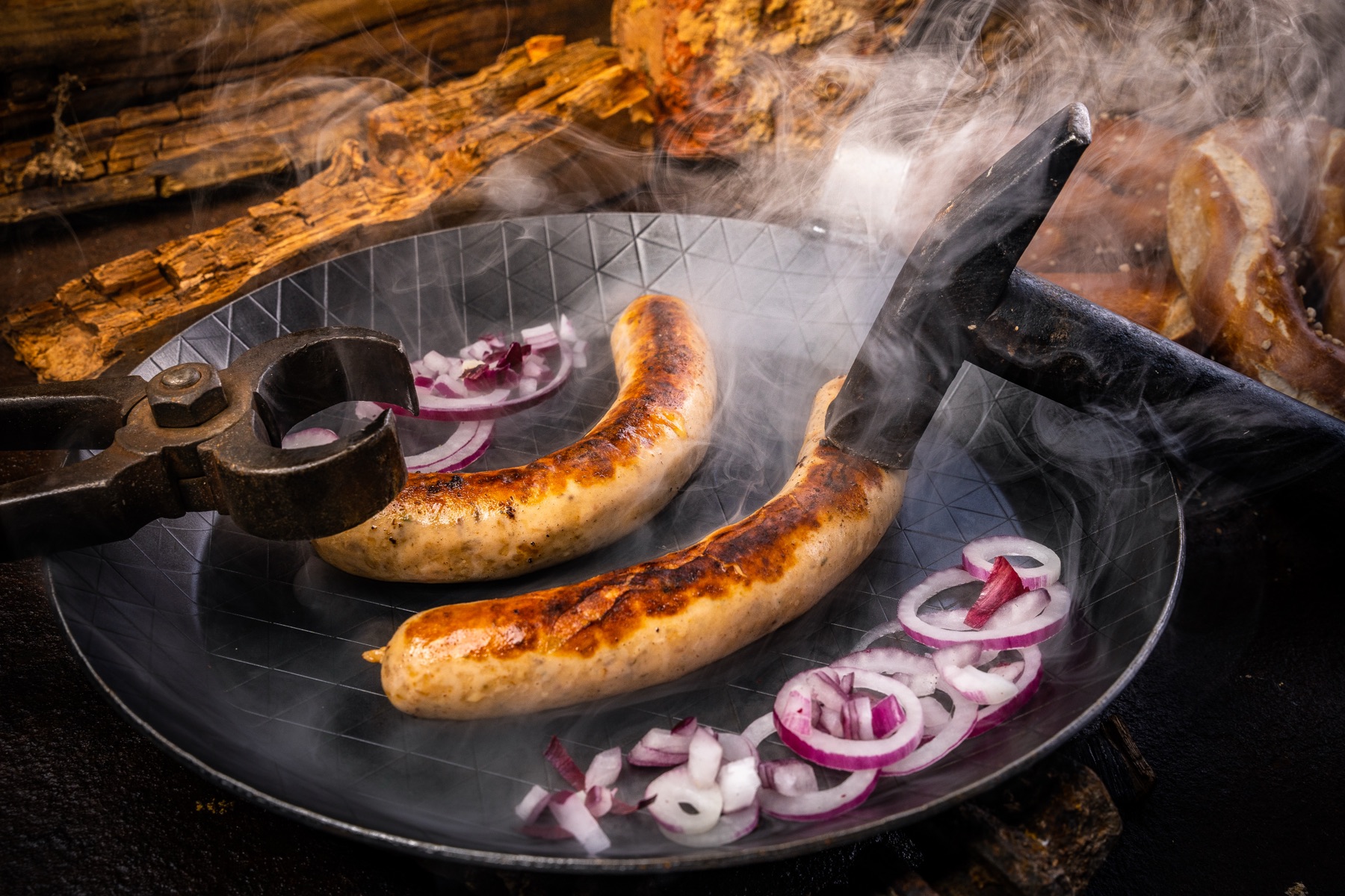 Würste in der gusseisernen Pfanne mit roten Zwiebeln