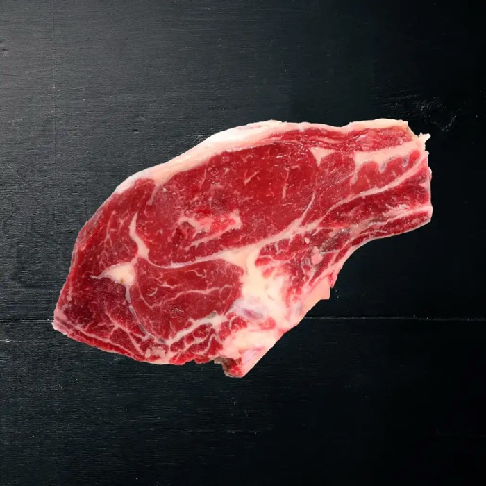 Rohes Steak auf dunklem Holz